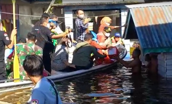 Mensos Risma Naik Perahu Pantau Banjir di Sanggau