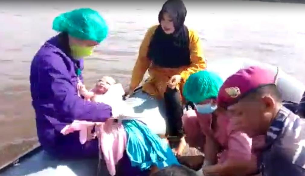 Proses kelahiran seorang bayi perempuan di atas perahu karet saat evakuasi korban banjir di Kabupaten Sekadau, Jumat (19/11/2021). Foto: DOK/ruai.tv