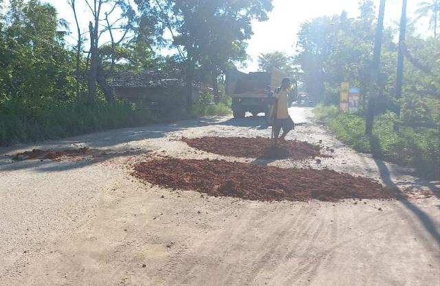 jalan rusak ditimbun